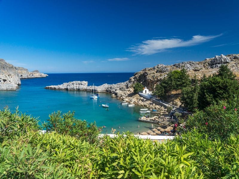 St Paul’s Bay with turquoise waters and rocky coastline featured in Lindos tours.