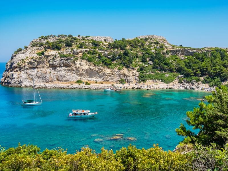 Sailboat near the medieval harbor and fortress during Rhodes Boat Trips.