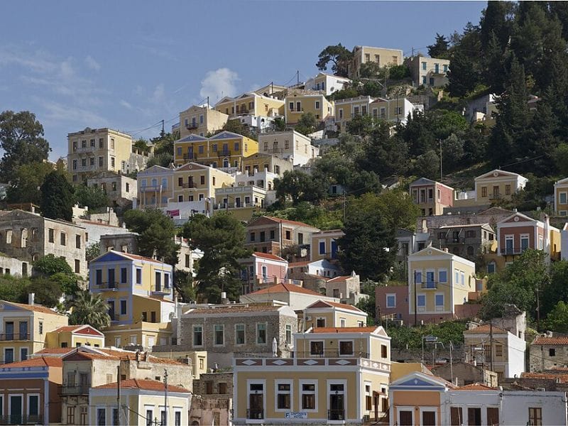 Pastel-colored hillside houses and traditional architecture featured in Symi island tours.