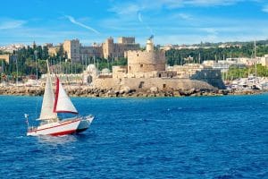 Sailboat near the medieval harbor during the best experiences in Rhodes.