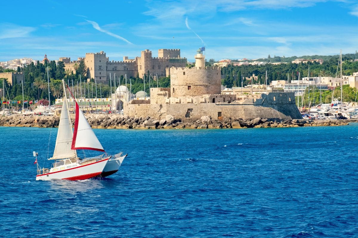 Sailboat near the medieval harbor during the best experiences in Rhodes.